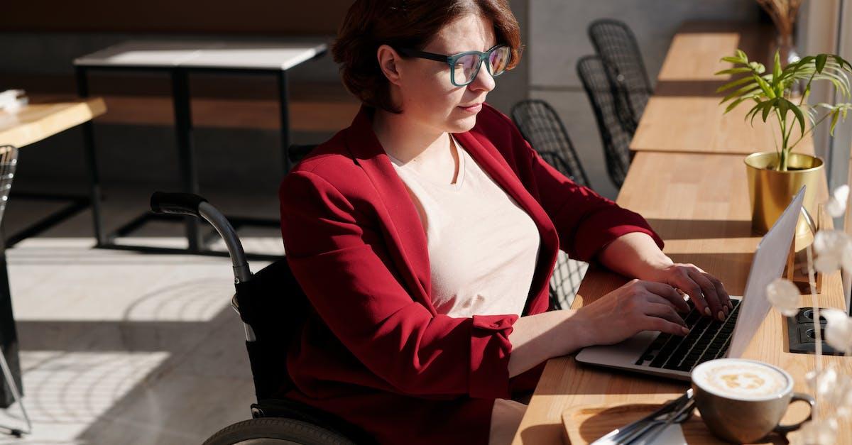 A woman in a wheelchair typing at a desk 